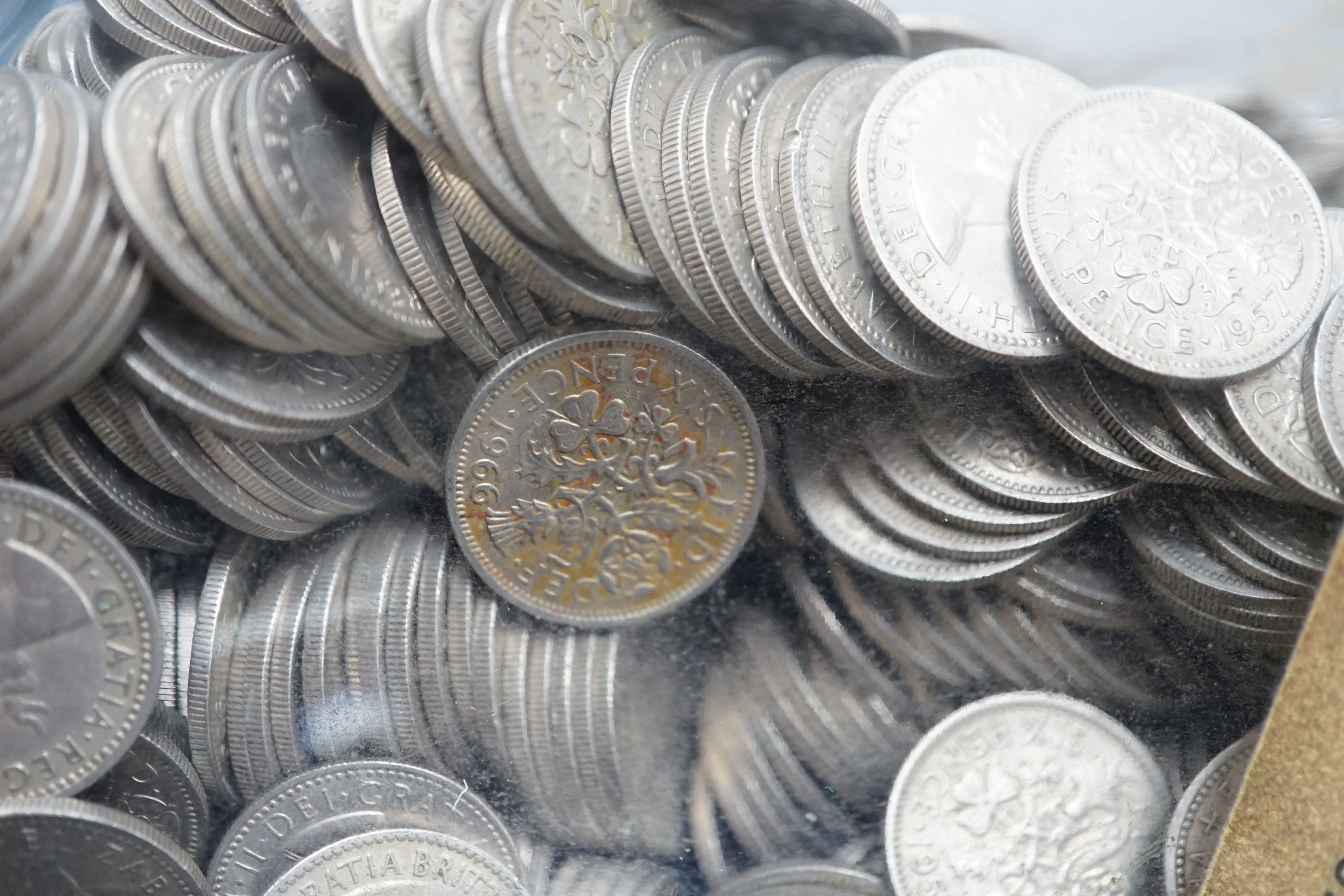 A large bag of UK pennies, coins and a bottle of sixpences